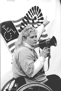 photo of an activist with a bullhorn mouthing off in front of a Don't Tread on Our ADA flag